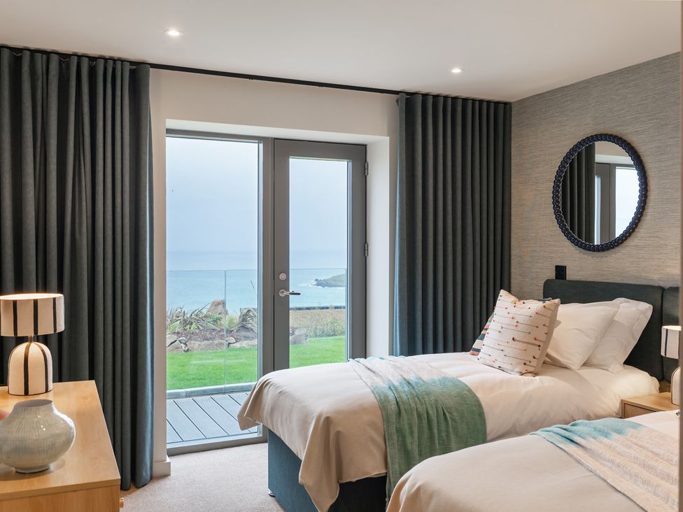 A bedroom with two beds and a sliding door at Hidden 19- Coastal Hot Tub in St Ives