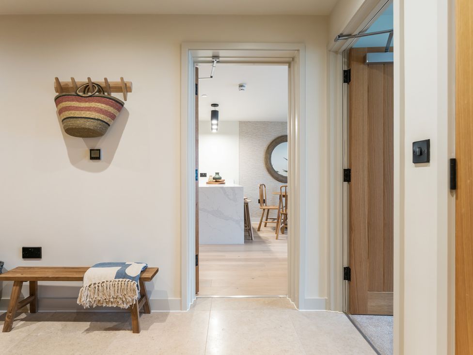 A hallway with a bench and a basket at Hidden 19- Coastal Hot Tub in St Ives