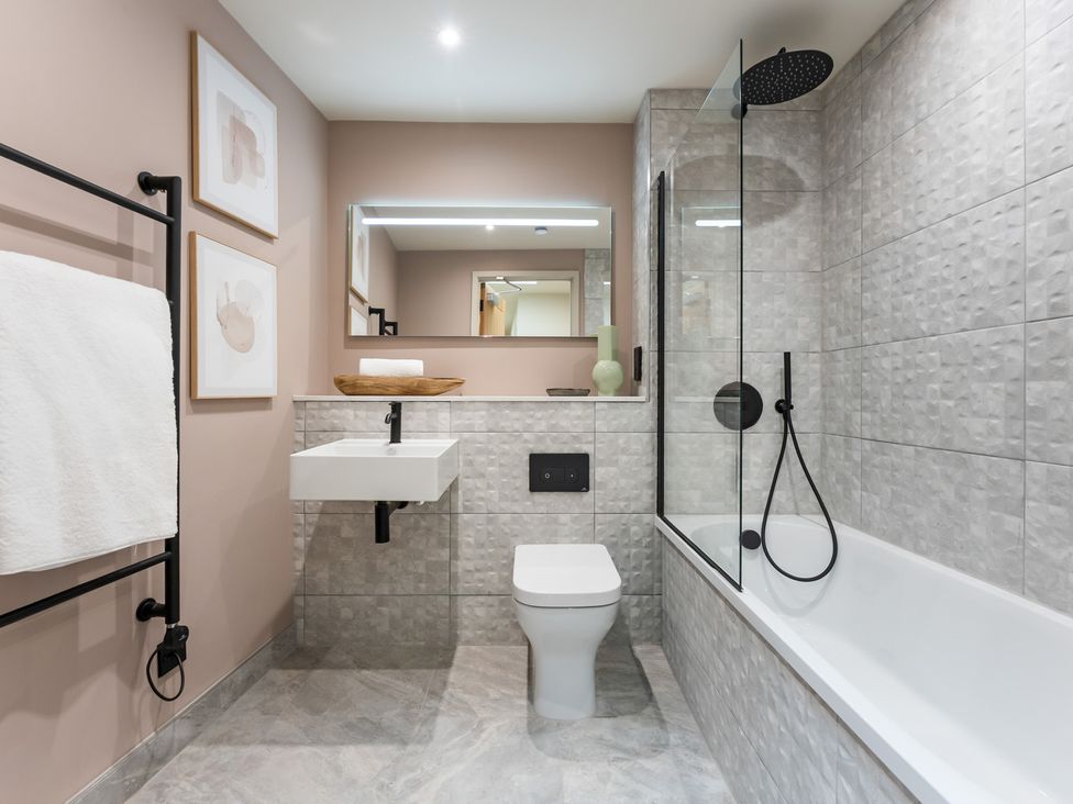 A bathroom with a bathtub, toilet, and sink at The Old Barn in St. Ives