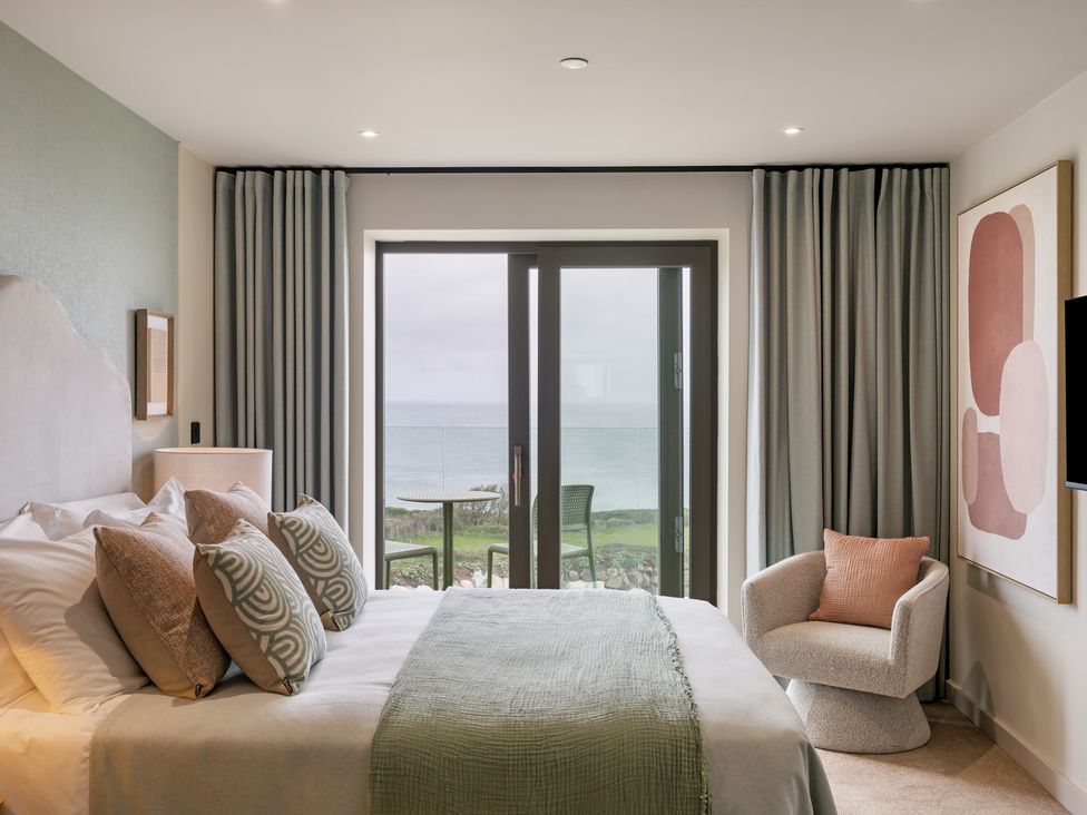 A bedroom with a bed and view of the ocean at tbc St. Ives