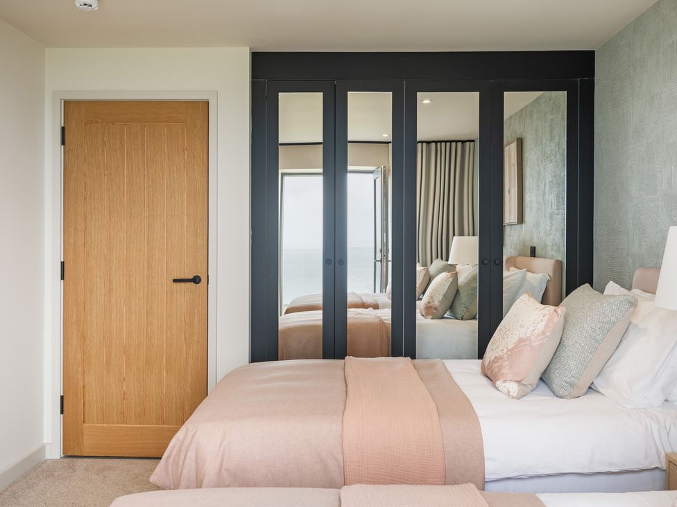 A bedroom with a bed and mirrored wardrobe at tbc in St. Ives