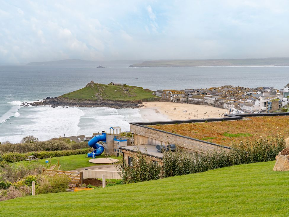 A view of the beach and ocean with a playground at tbc St. Ives