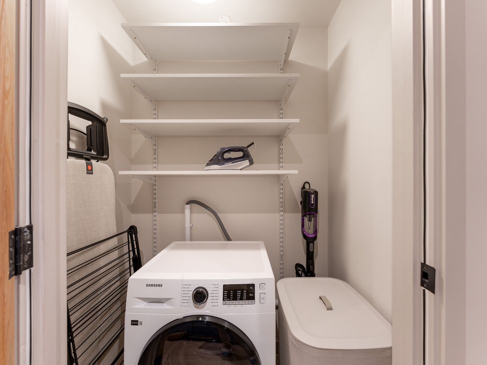 A laundry room with a washing machine and an iron at Hidden 20- Gallery Hot Tub St Ives