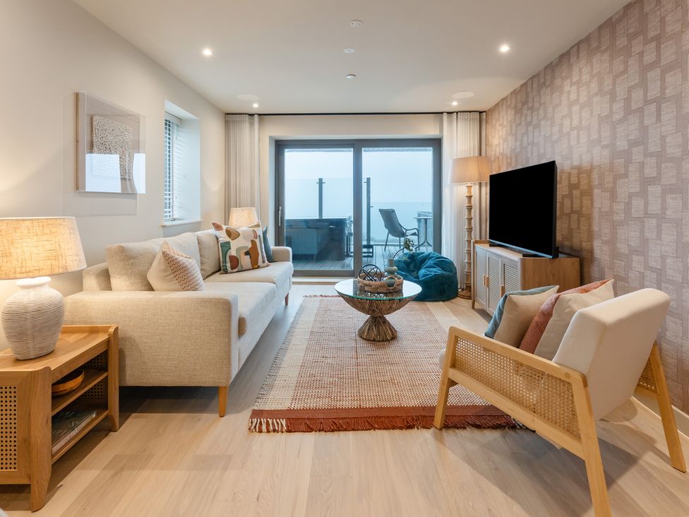 A living room with a sofa, coffee table, and television at tbc in St. Ives