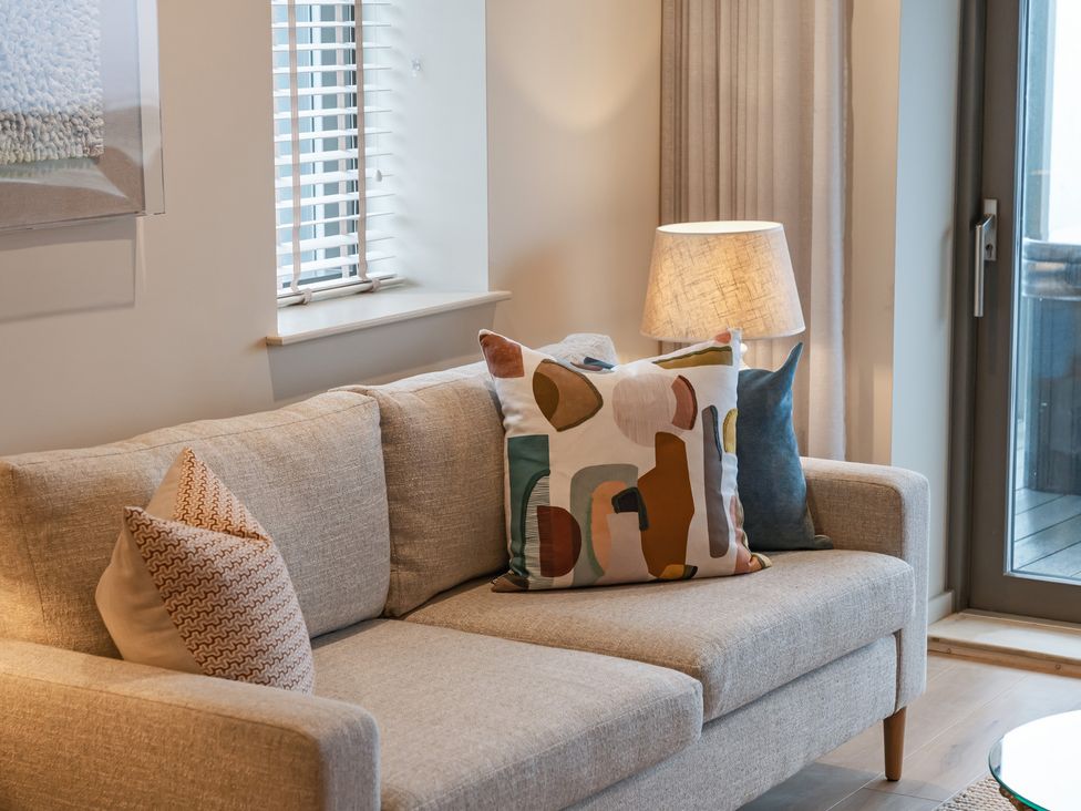 A living room with a sofa and pillows at tbc in St. Ives