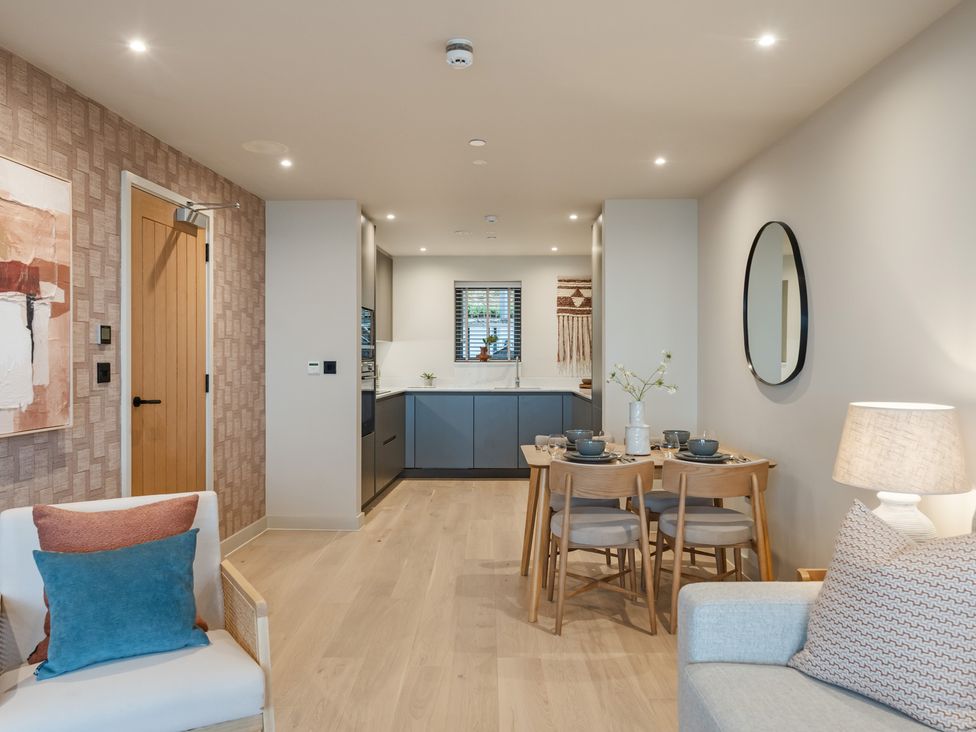 A living room with a kitchen area and dining table at tbc in St. Ives