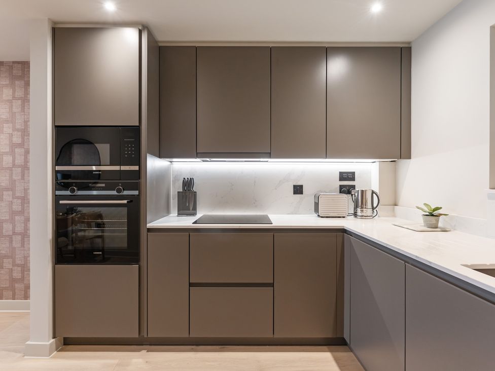 A kitchen with cabinets, stove, oven, kettle and toaster at tbc St. Ives
