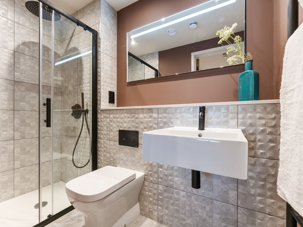 A bathroom with shower, toilet, and sink at The Old Barn in St. Ives