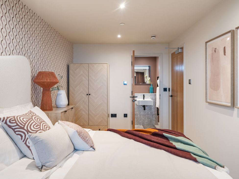 A bedroom with a bed, wardrobe, and bathroom door at tbc in St. Ives