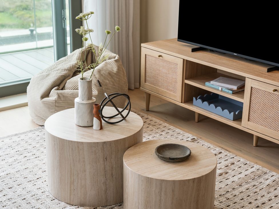 A living room featuring round tables and a television at tbc St. Ives