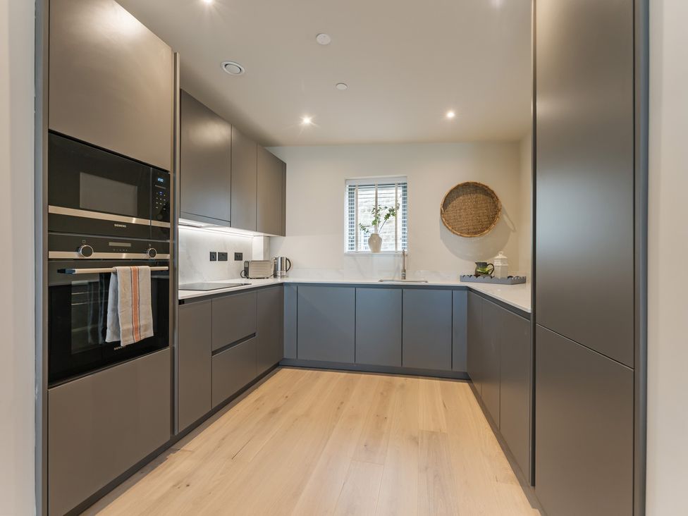 A kitchen with modern cabinets and appliances at tbc St. Ives