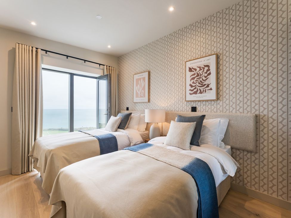 A bedroom with two beds and a window overlooking the sea at tbc St. Ives