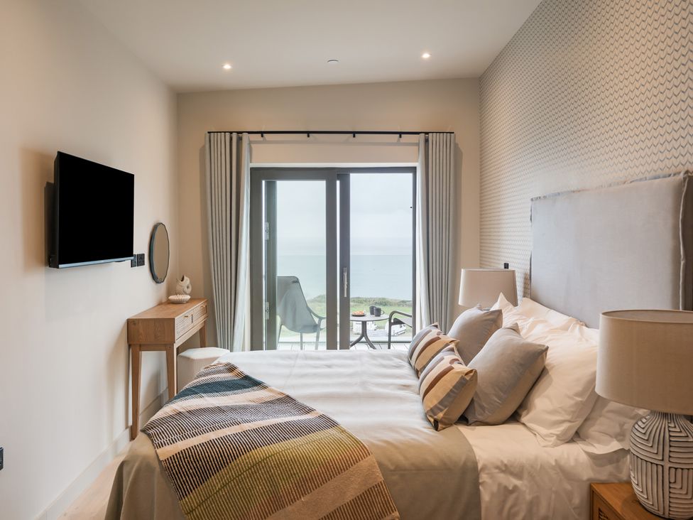 A bedroom with a bed and sliding door at tbc in St. Ives
