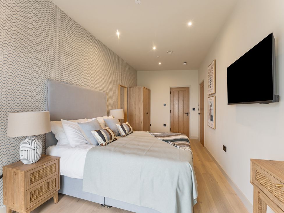 A bedroom with a bed and side tables at tbc in St. Ives