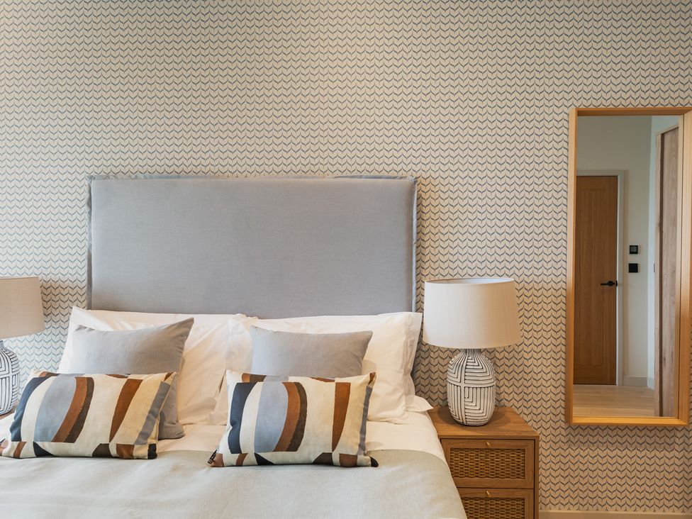 A bedroom with a bed and a mirror at tbc St. Ives