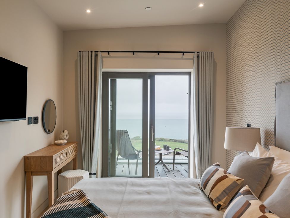 A bedroom with a bed and sliding door to a balcony at tbc St. Ives
