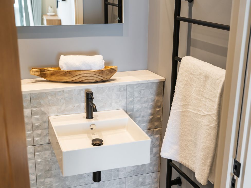 A bathroom with a sink and towels on a rack at tbc in St. Ives