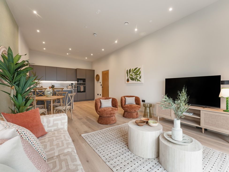 A living room with a sofa and dining area at tbc in St. Ives
