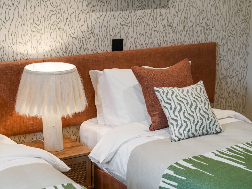 A bedroom with two beds and a lamp at tbc in St. Ives