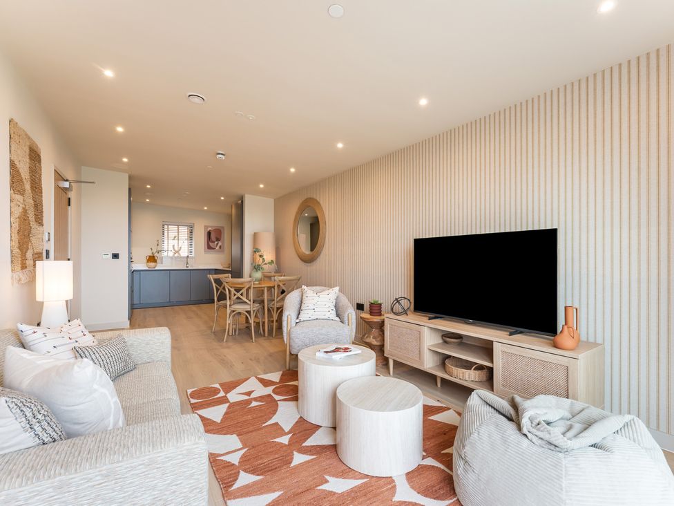 A living room with a sofa and television at Hidden 10- Godrevy View in St Ives