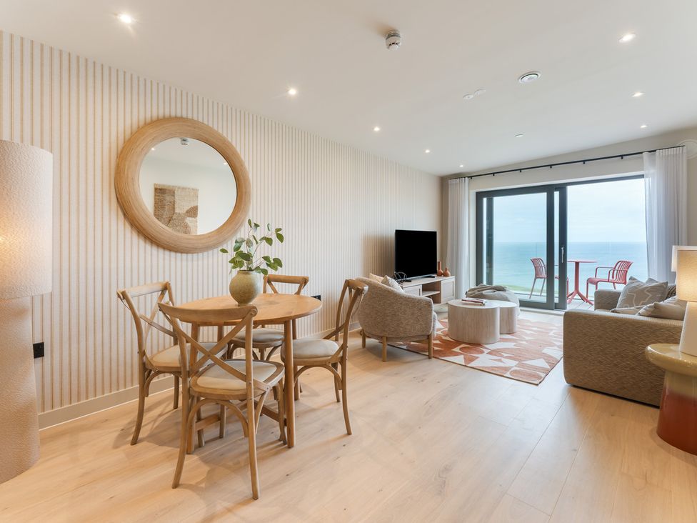 A living room with a table and chairs at Hidden 10- Godrevy View, St Ives