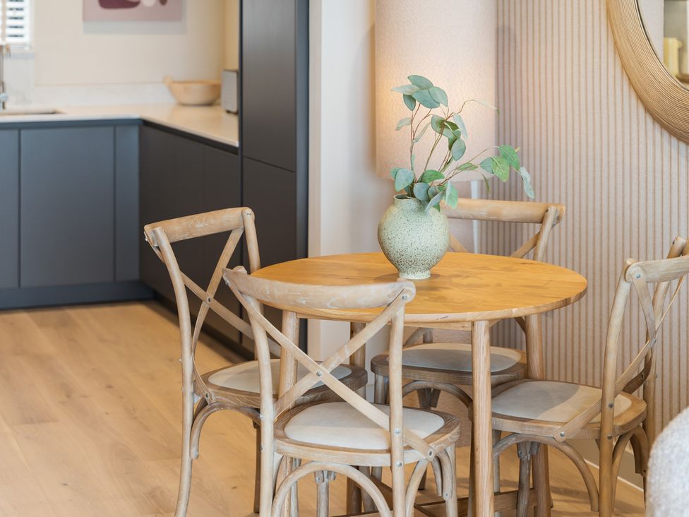 A dining room with a wooden table and chairs at Hidden 10- Godrevy View in St Ives