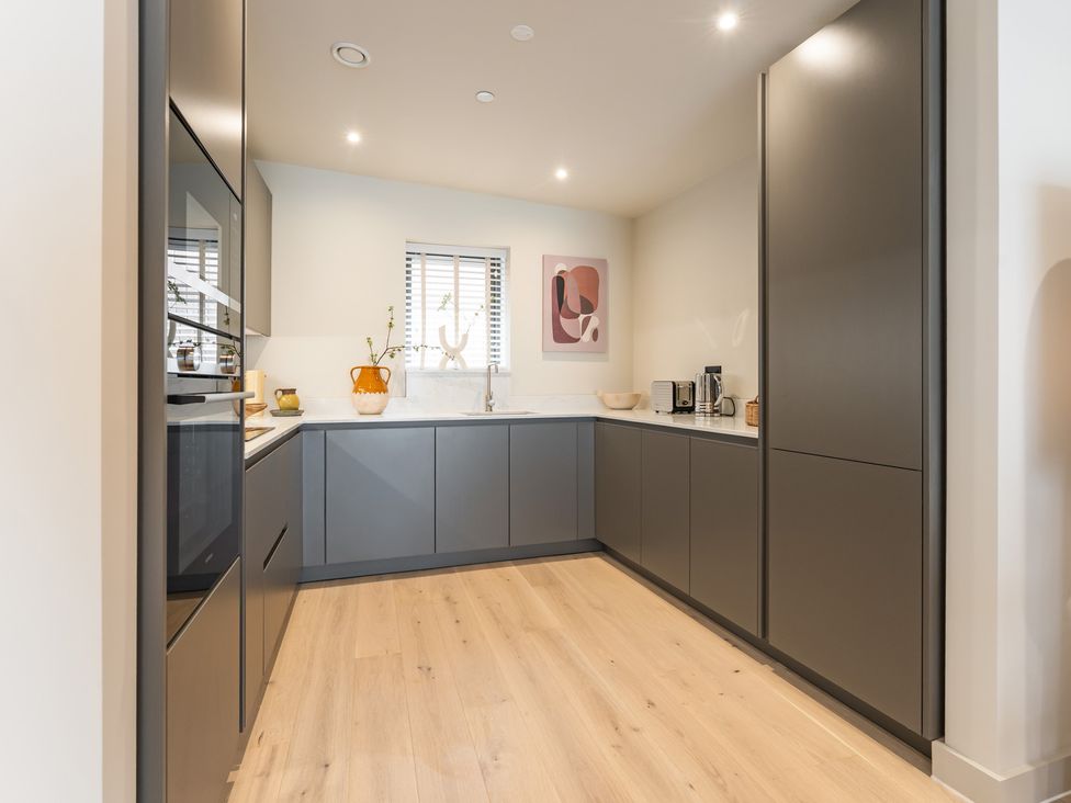A kitchen with cabinets and appliances at Hidden 10- Godrevy View in St Ives
