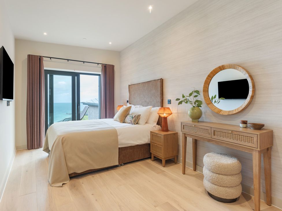 A bedroom with a bed and a window at Hidden 10- Godrevy View in St Ives