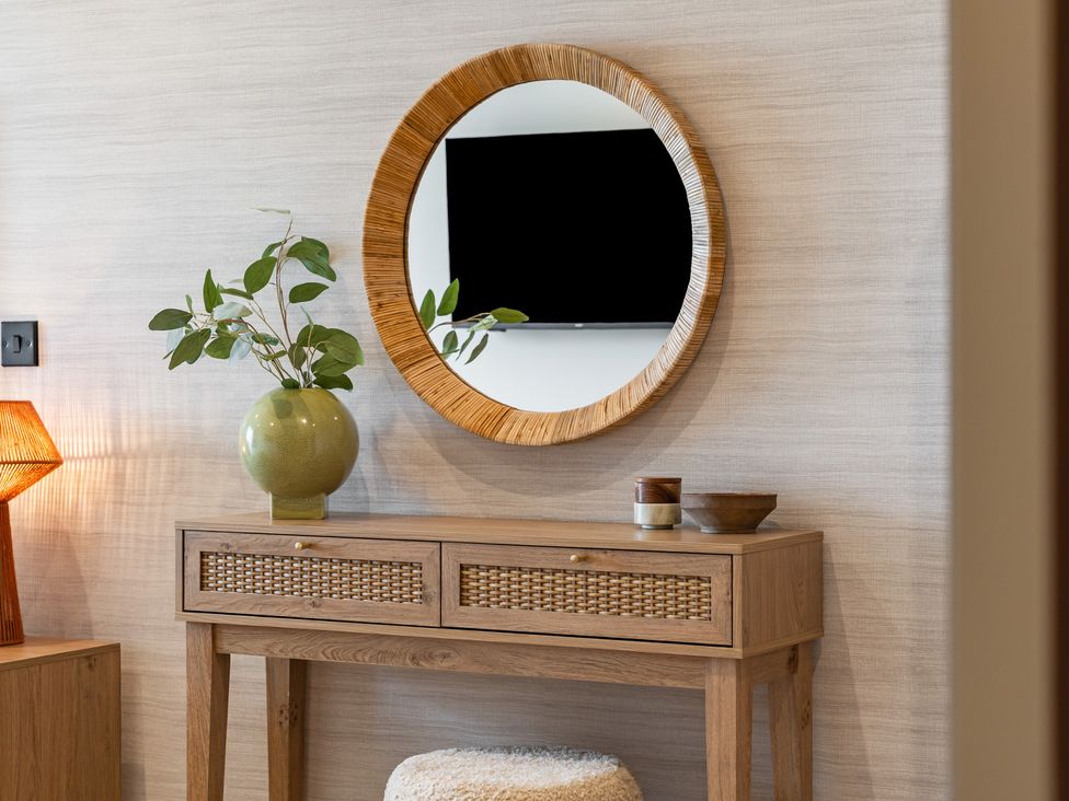 A table with a mirror and plant in the living room at Hidden 10- Godrevy View, St Ives