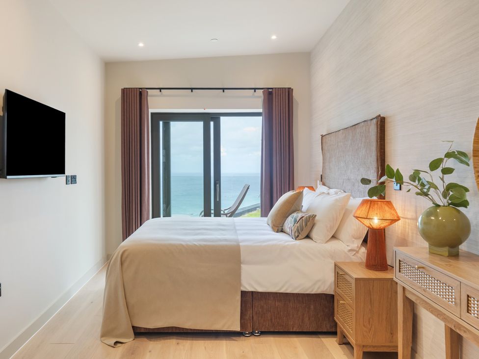 A bedroom with bed and television at Hidden 10- Godrevy View in St Ives