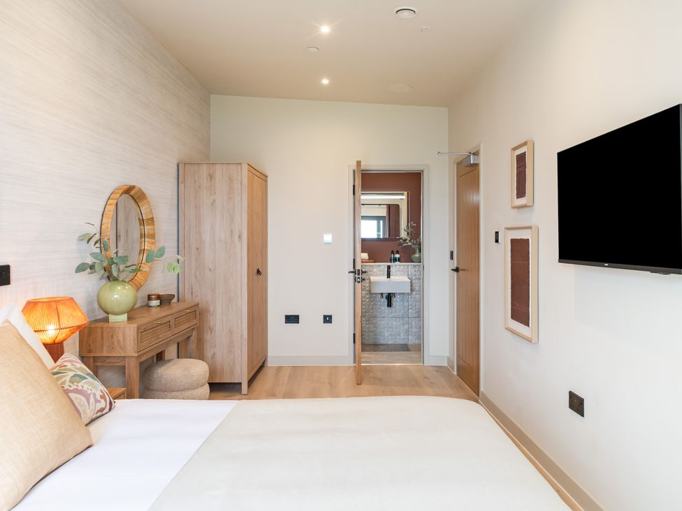 A bedroom with a bed and wardrobe at Hidden 10- Godrevy View in St Ives