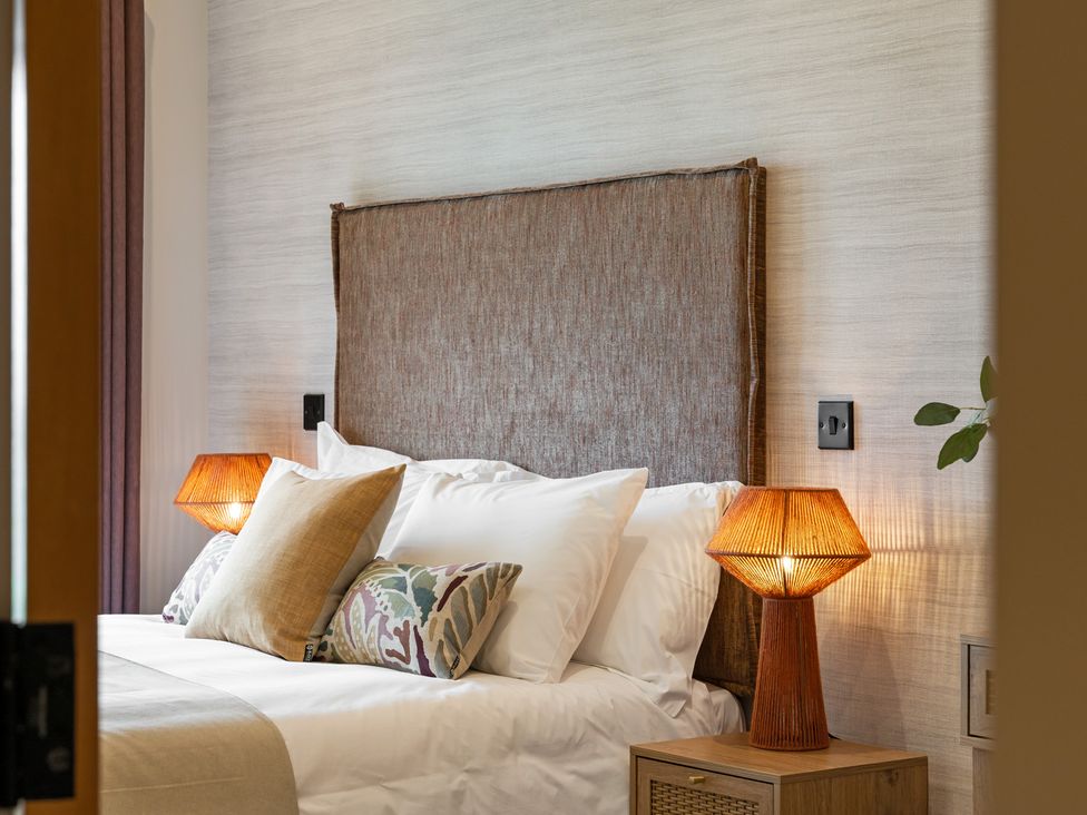 A bedroom with a bed and bedside lamps at Hidden 10- Godrevy View, St Ives