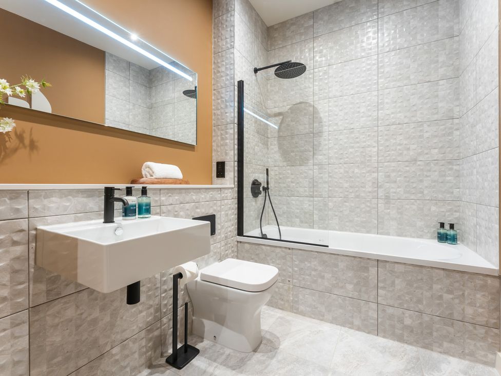 A bathroom with a bathtub and sink at Hidden 10- Godrevy View in St Ives