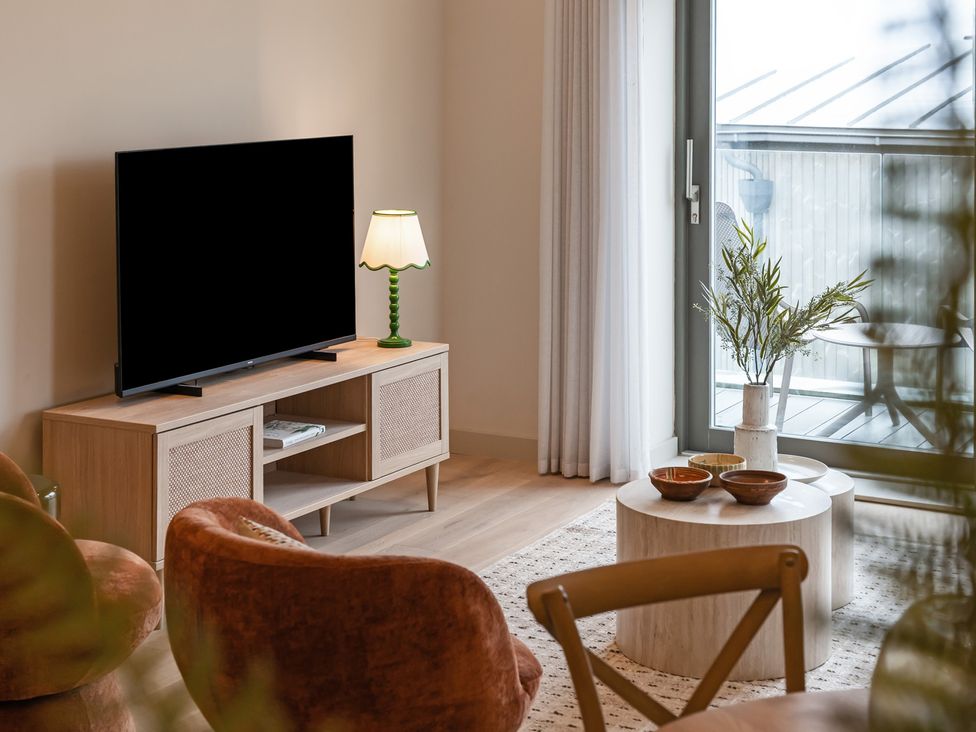 A living room with a television and seating at The Old Barn in St. Ives