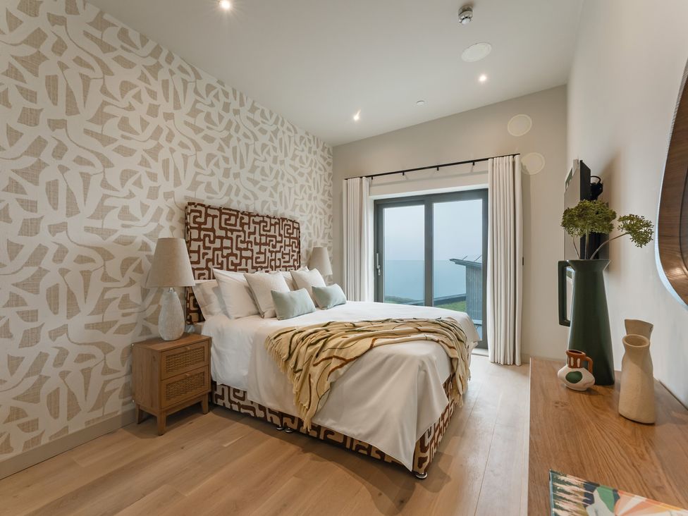 A bedroom with a bed and sliding door at tbc in St. Ives