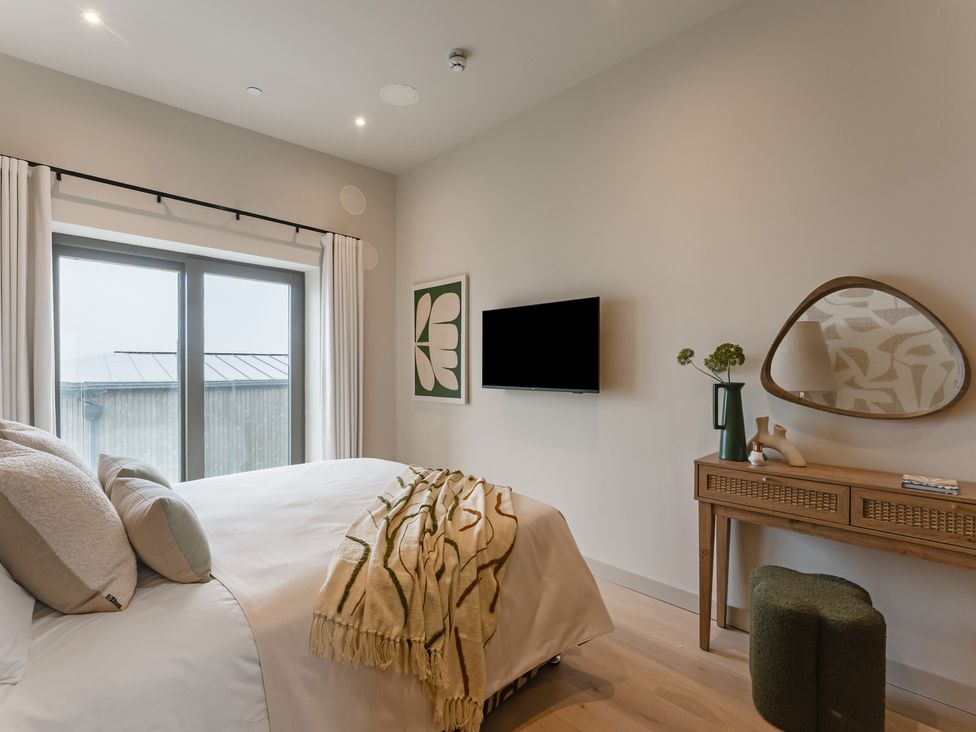 A bedroom with a bed and television at tbc in St. Ives