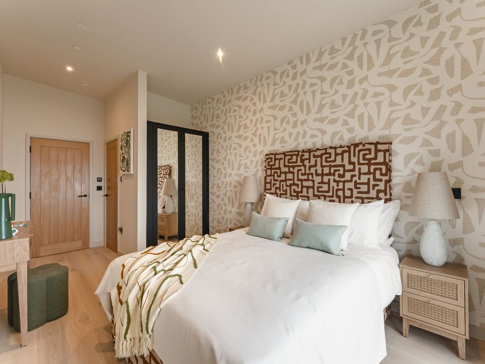 A bedroom with a bed and nightstands at tbc in St. Ives
