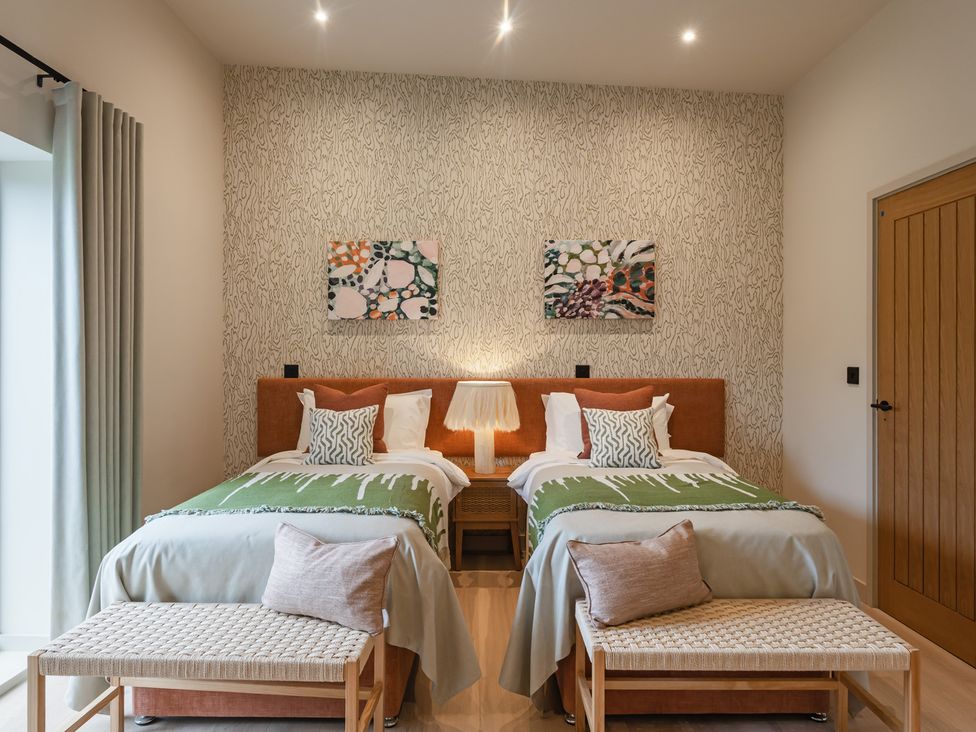 A bedroom with two beds and artwork at tbc in St. Ives