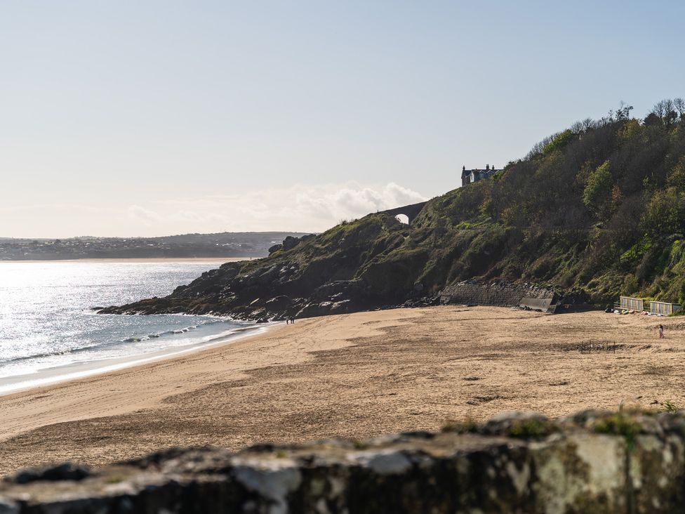 A beach with sand and rocks at Hidden 11- Porthmeor View St Ives