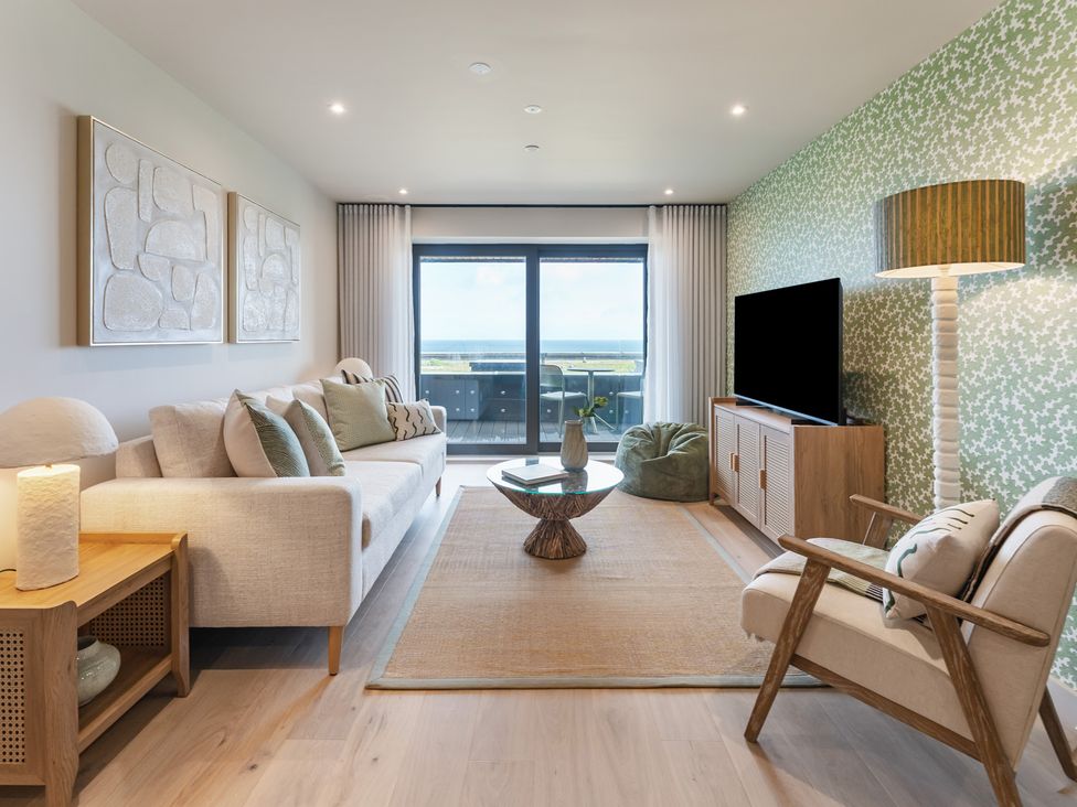 A living room with a sofa, coffee table, and television at tbc in St. Ives