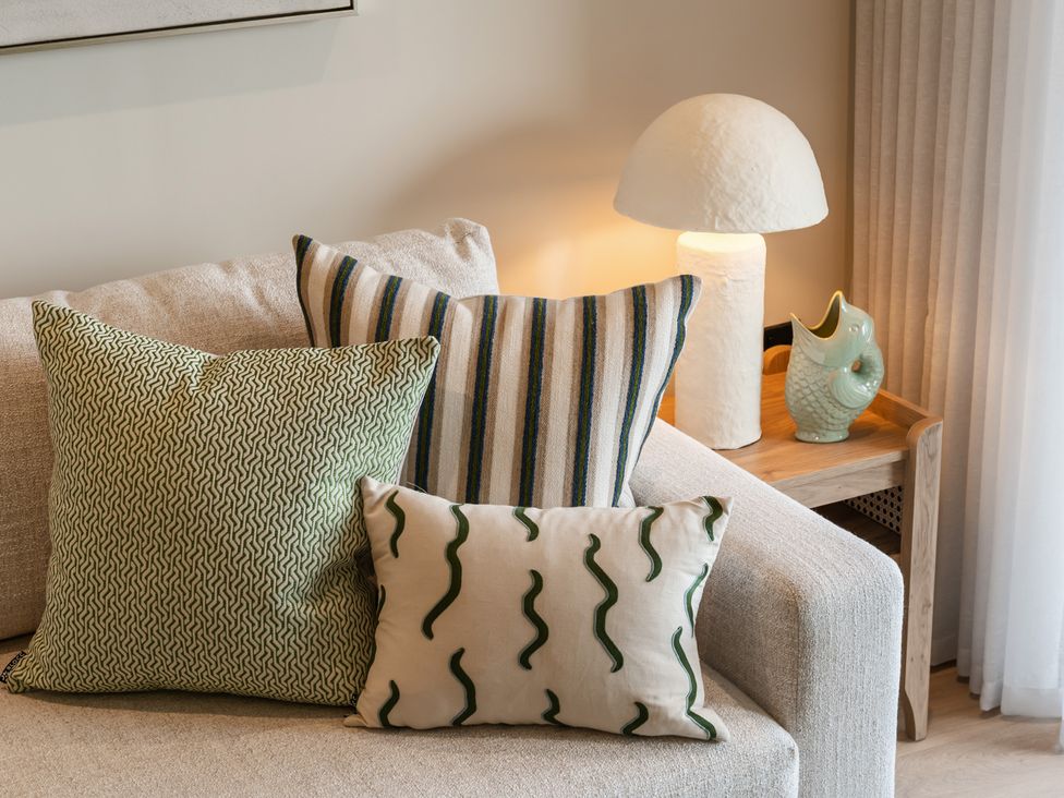 A living room with cushions and a lamp at tbc in St. Ives