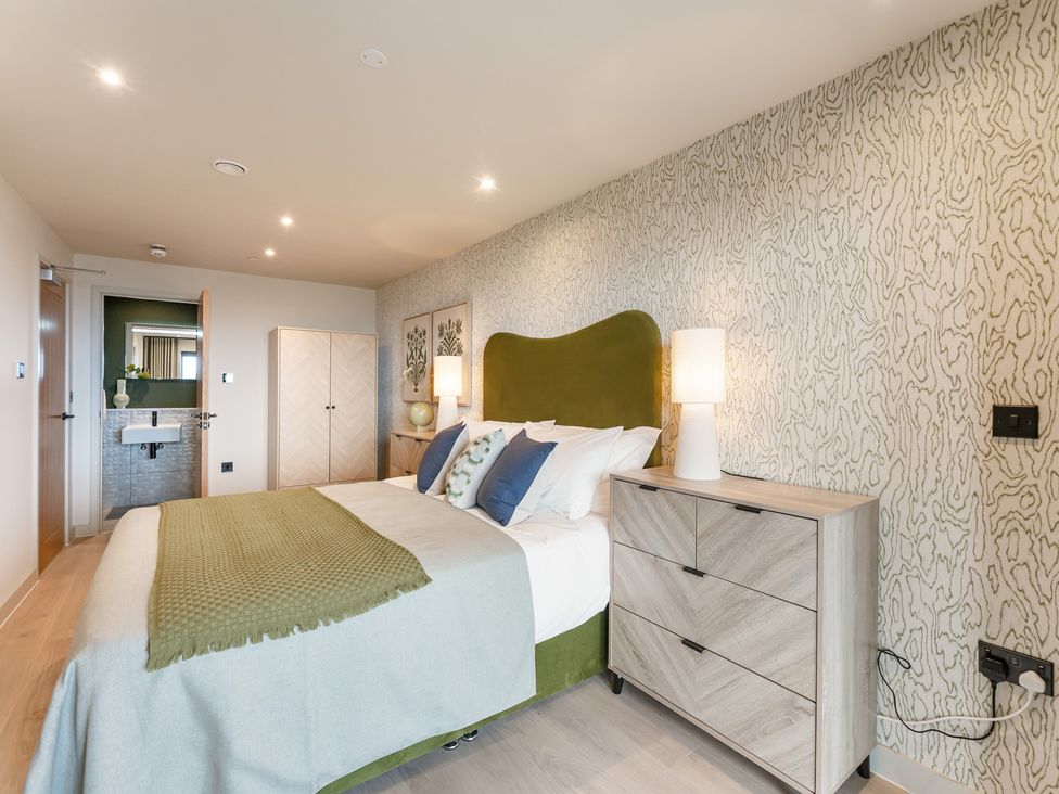 A bedroom with a bed and dresser at tbc in St. Ives