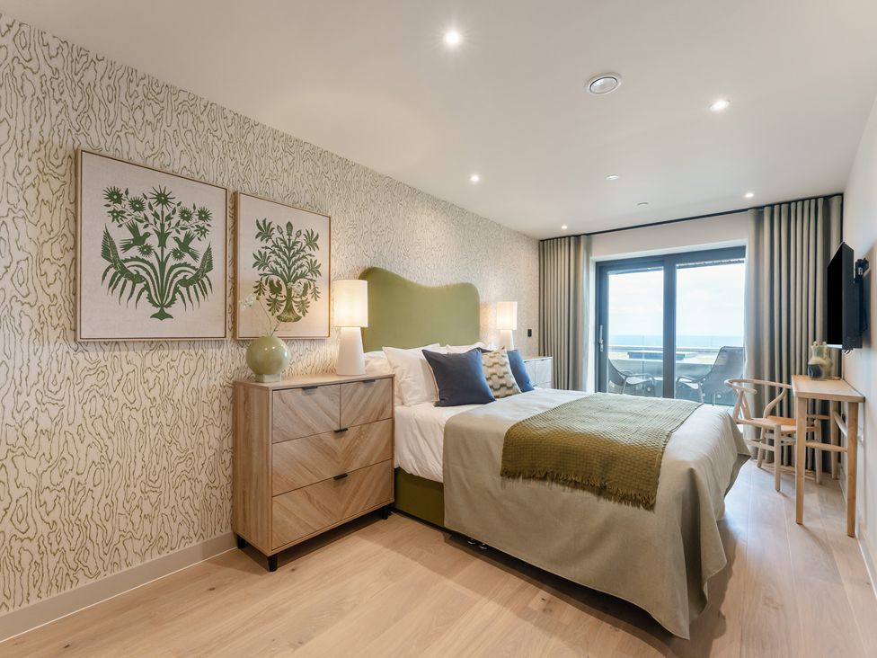 A bedroom with a bed and artwork at tbc in St. Ives