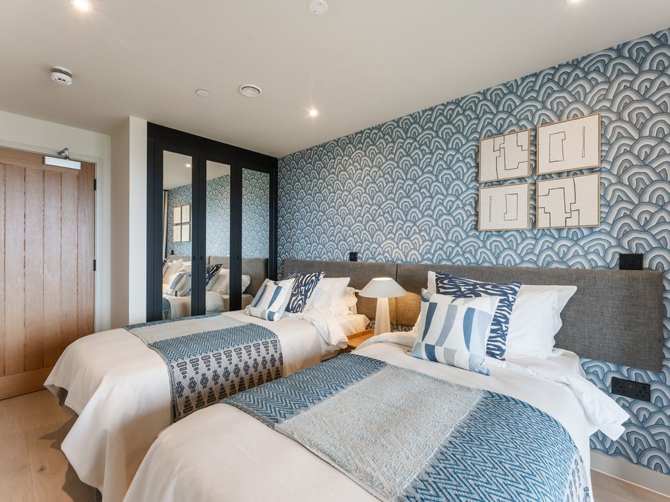 A bedroom with two beds and a lamp at tbc in St. Ives