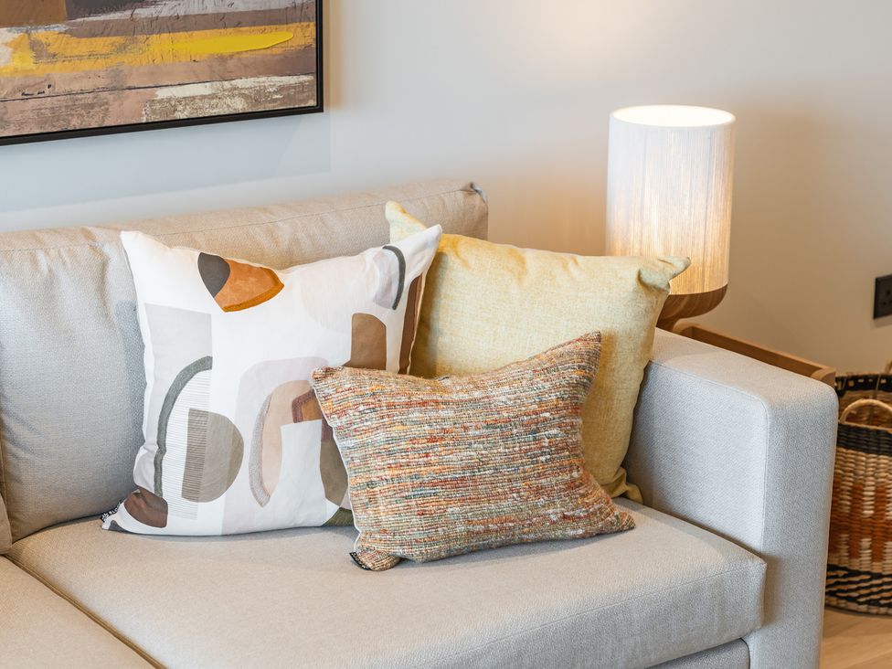 A living room with a sofa and decorative pillows at tbc in St. Ives