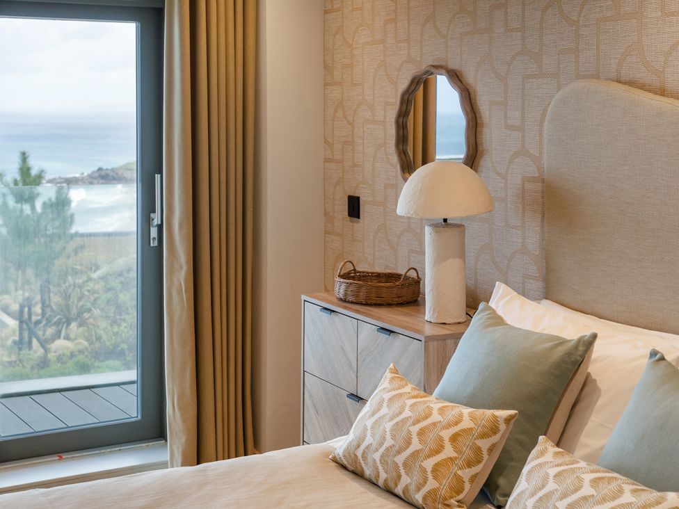 A bedroom with a bed, pillows, and a lamp at tbc in St. Ives