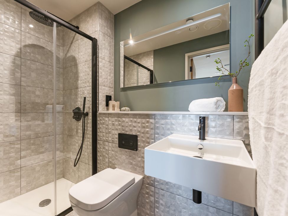 A bathroom with a shower, sink, and toilet at tbc in St. Ives