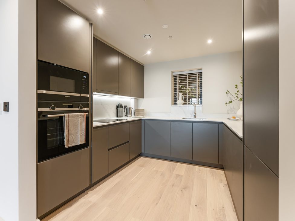 A kitchen with cabinets, oven, sink and window at tbc in St. Ives