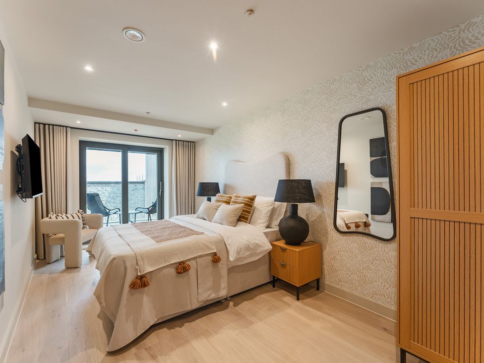 A bedroom with a bed and nightstand at tbc in St. Ives