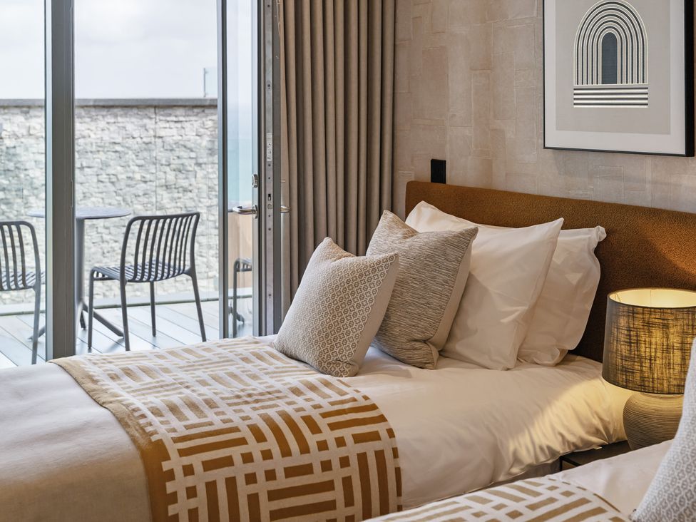 A bedroom with twin beds and a view at tbc in St. Ives